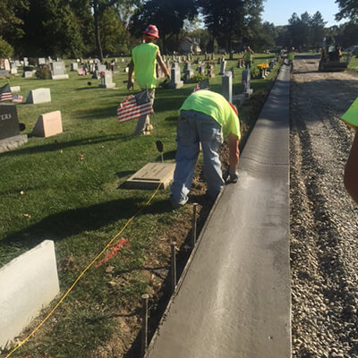 Construction workers building a concrete curb